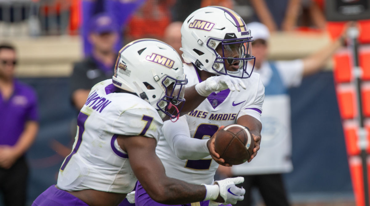 James Madison quarterback Jordan McCloud hands the ball off to running back Ty Son Lawton during the Dukes’ 36–35 win over Virginia on Sept. 9, 2023.