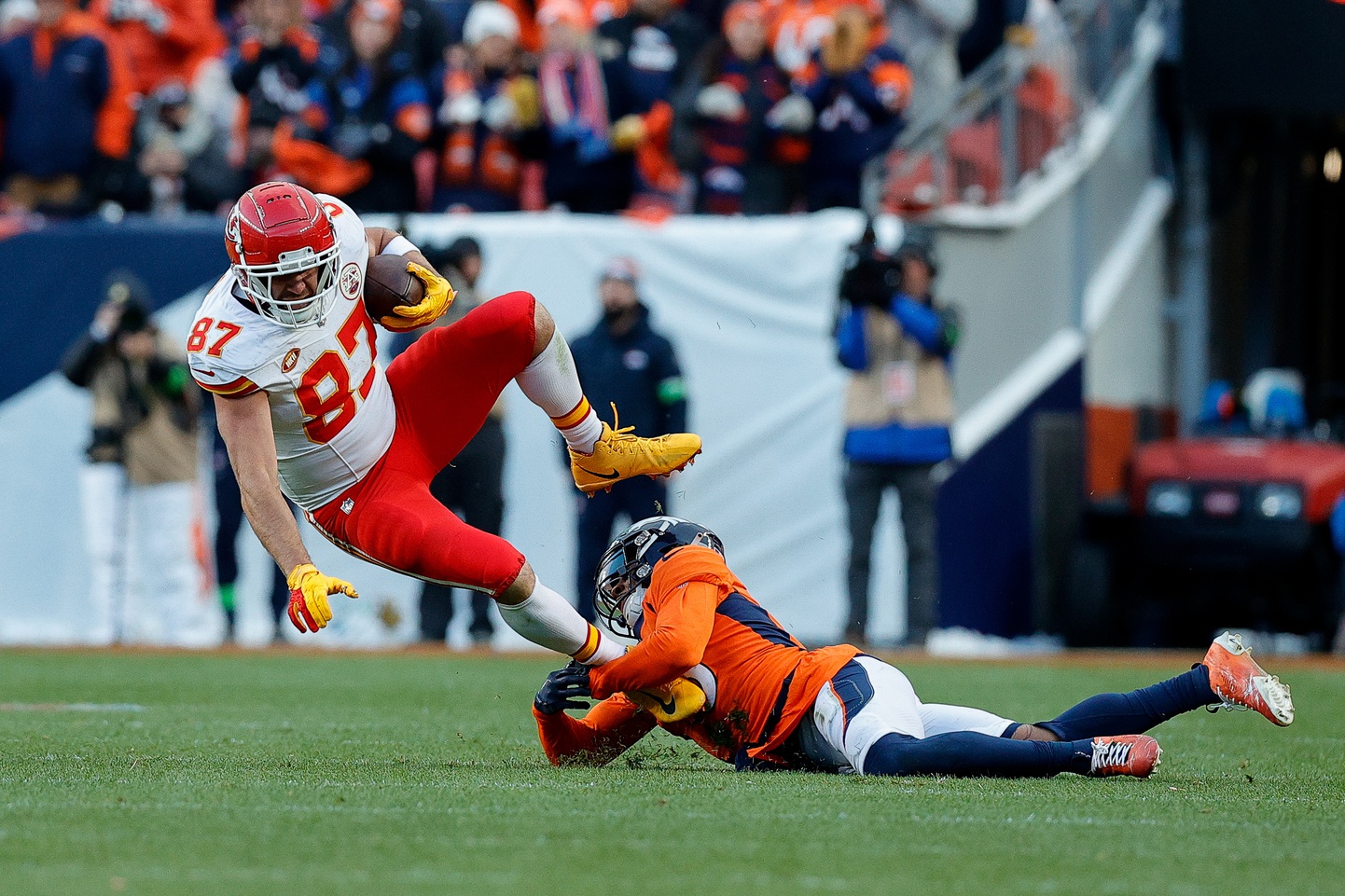 Kansas City Chiefs tight end Travis Kelce (87) is tackled by Denver Broncos safety P.J. Locke (6) in the fourth quarter at Empower Field at Mile High.