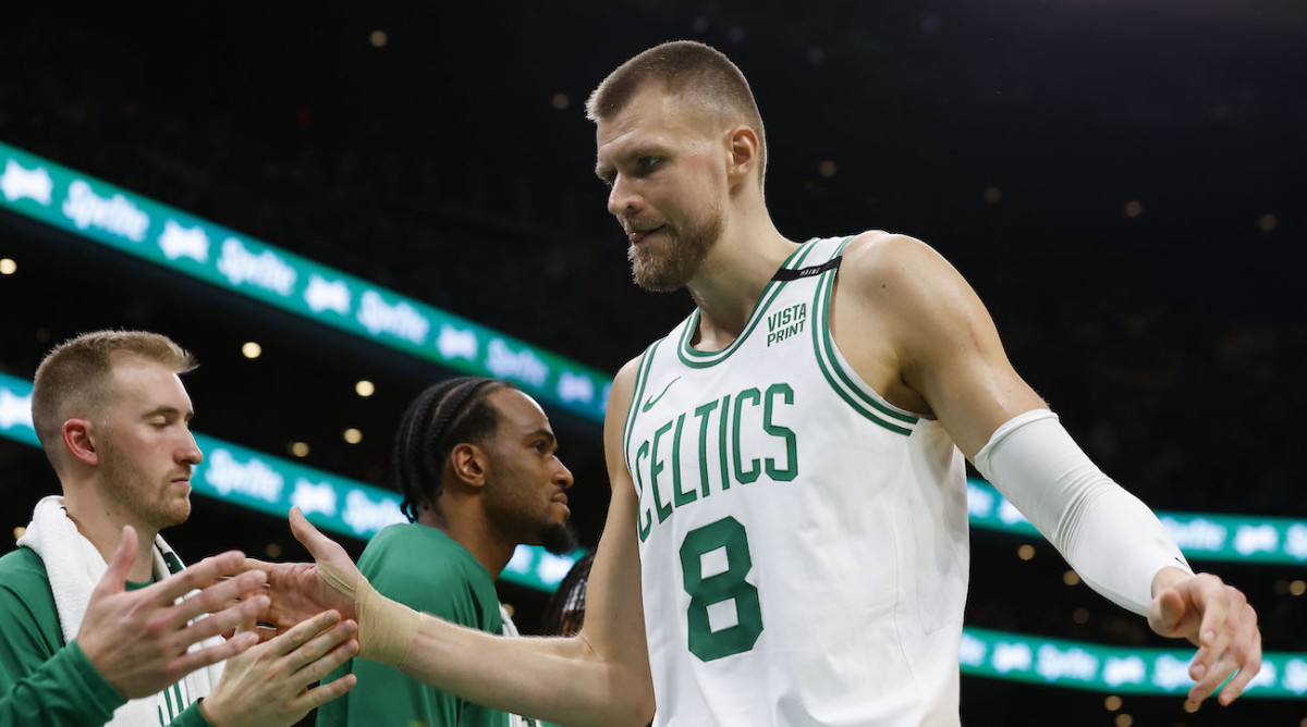Boston Celtics forward Kristaps Porziņģis high-fives teammates.