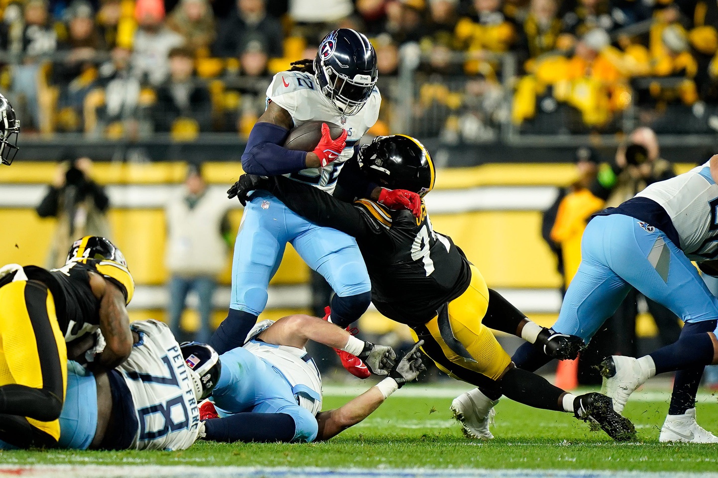 Tennessee Titans running back Derrick Henry (22) takes a hit from Pittsburgh Steelers defensive tackle Larry Ogunjobi (99).