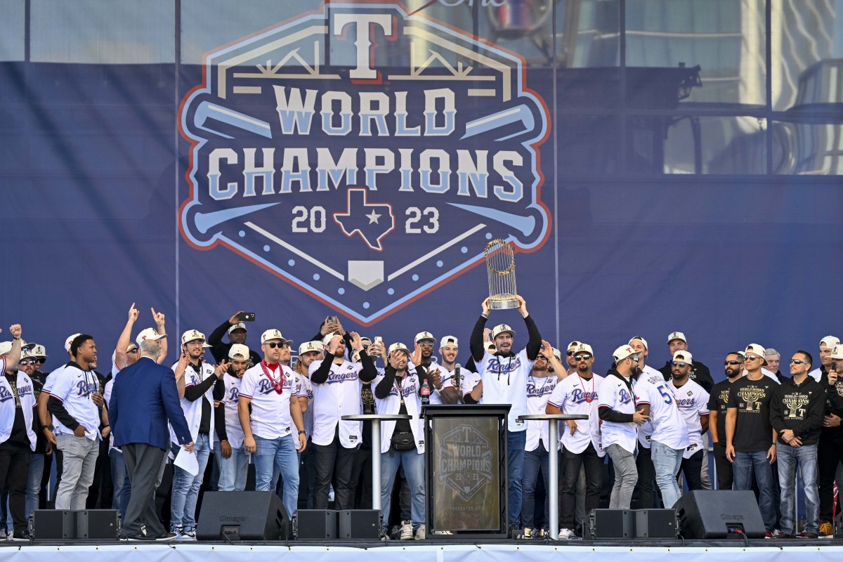 Texas Rangers starting pitcher Andrew Heaney raises the trophy during the celebration outside of the ballpark after the World Series championship parade at Globe Life Field.