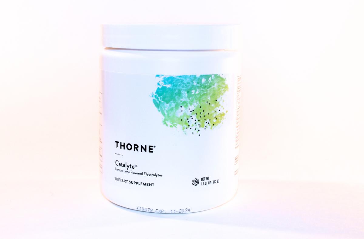 A white and teal container of Thorne Catalyte electrolyte drink mix in Lemon Lime flavor against a white background