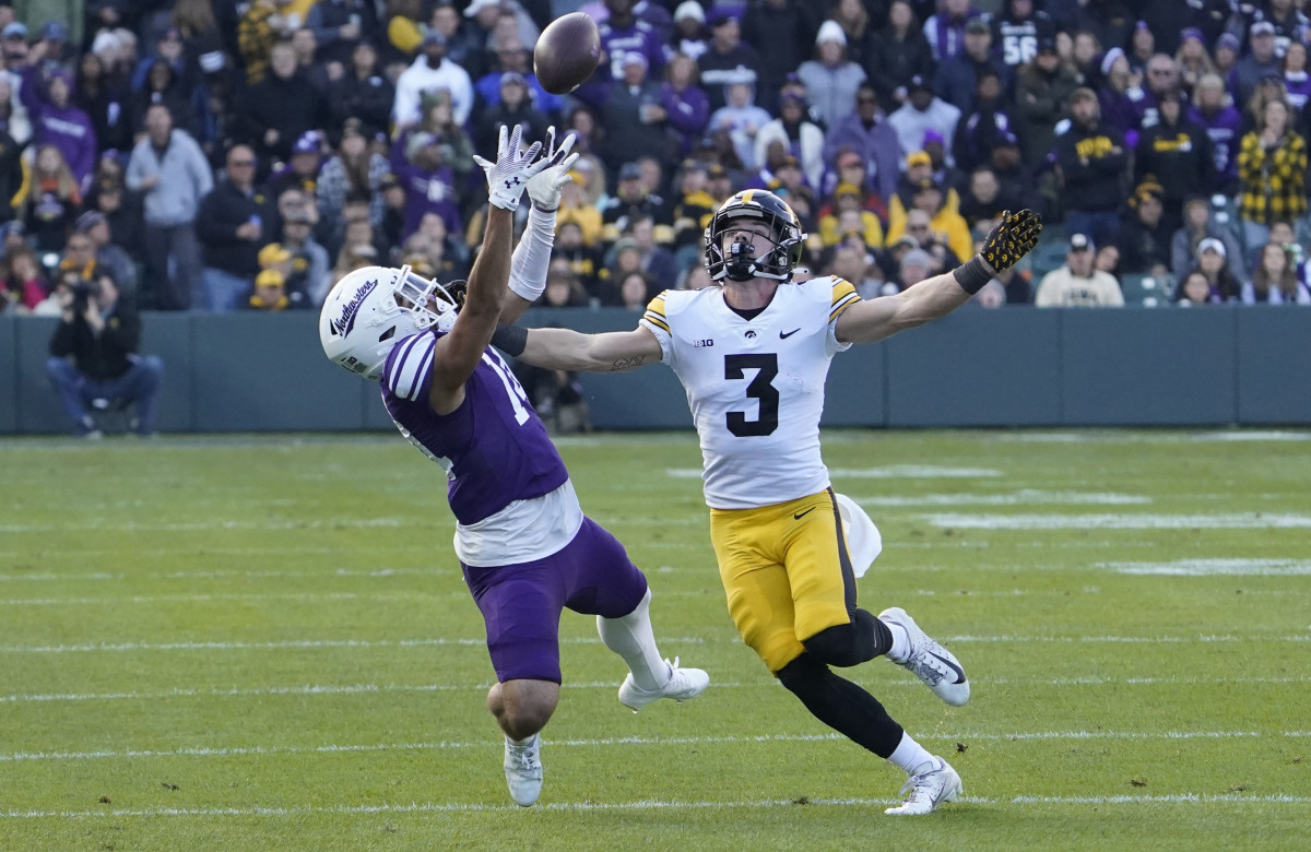 Northwestern wide receiver Cam Johnson attempts to catch a pass while defended by Iowa defensive back Cooper DeJean during the Wildcats' game against the Hawkeyes on Nov. 4, 2023.