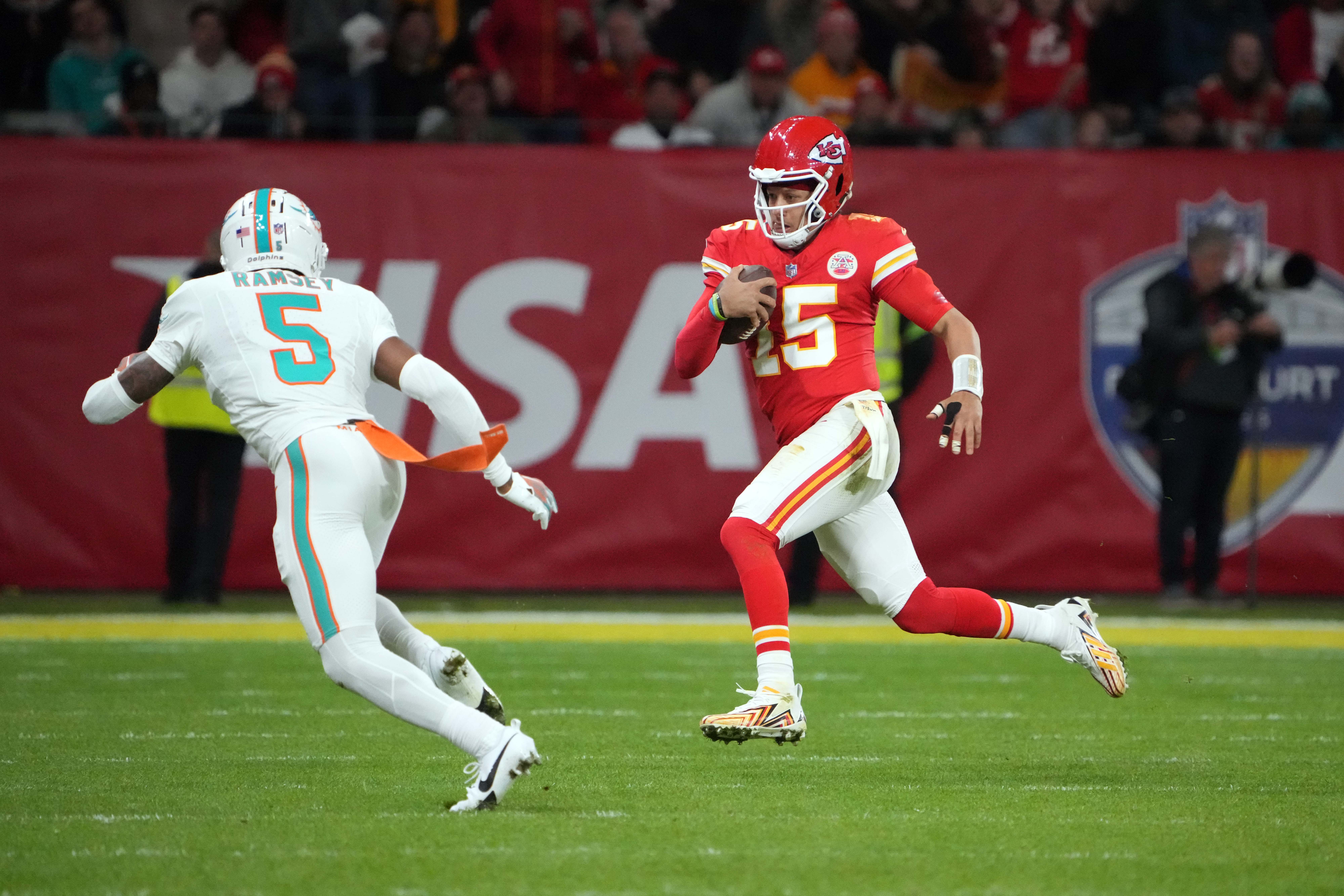 Patrick Mahomes holds the ball running as Jalen Ramsey runs toward him