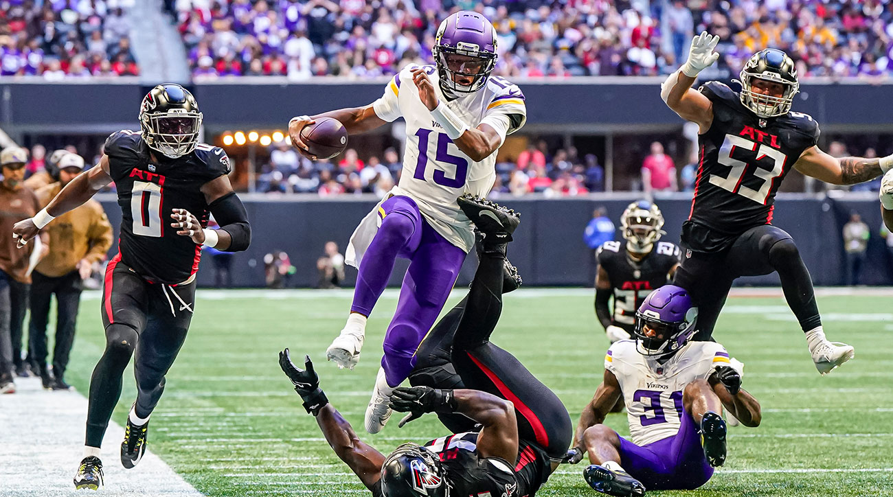 Joshua Dobbs jumps over a defender in his first game with the Vikings