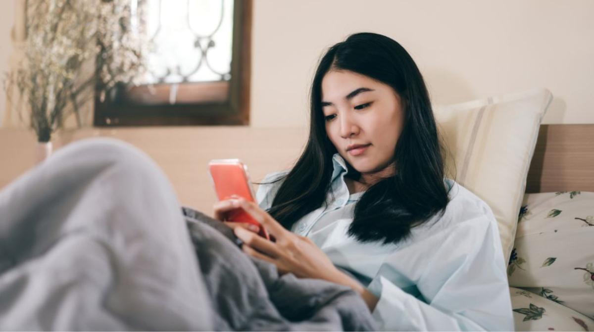 A woman using her phone in bed