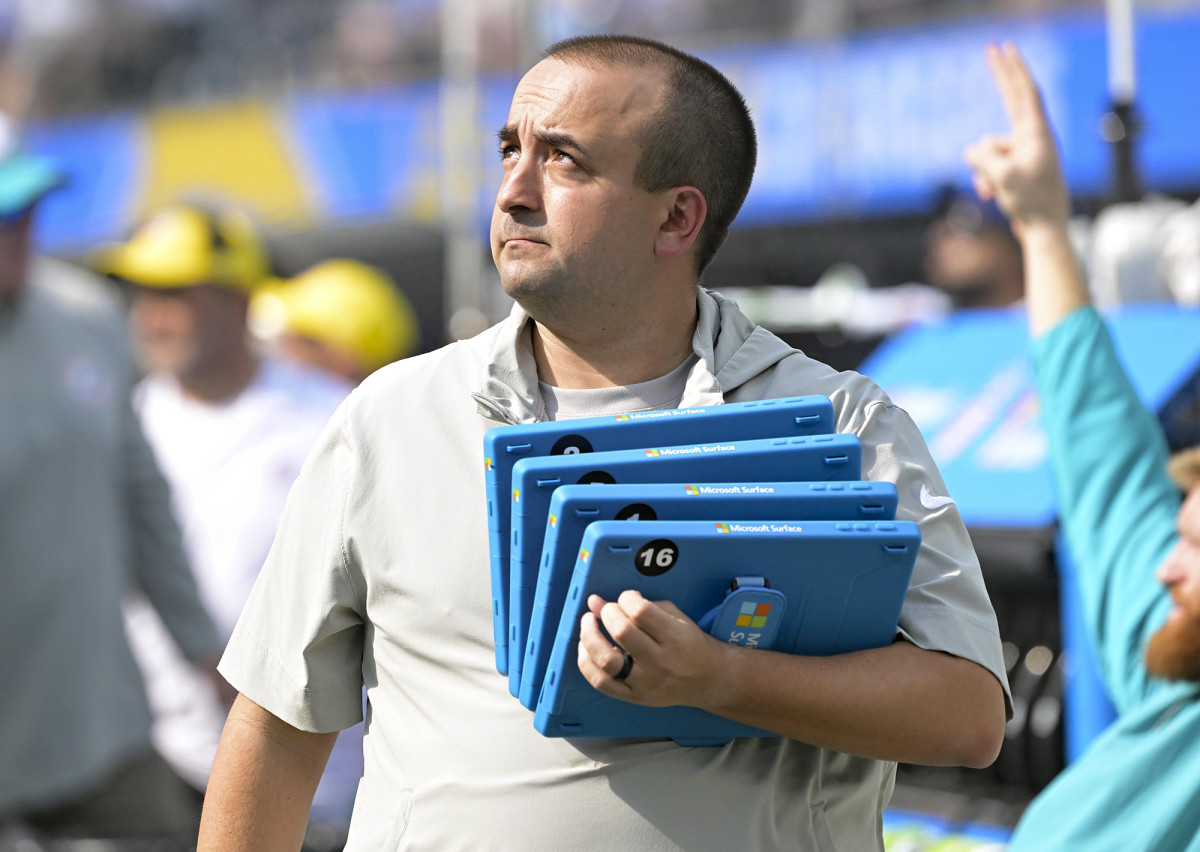 Dolphins football systems specialist Patrick Oliver holds Microsoft Surface tablets on the sideline.