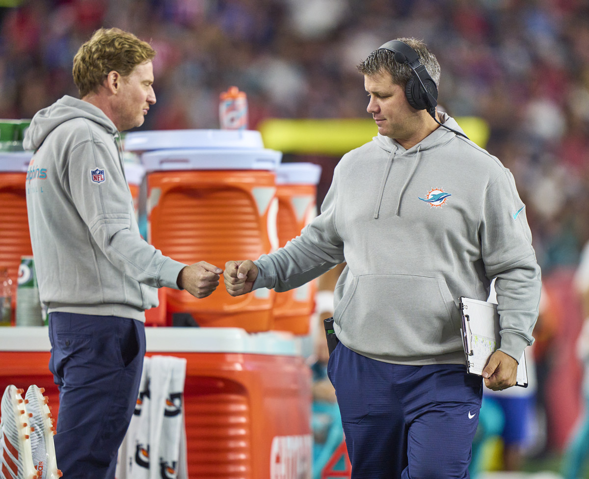 Dolphins video director Mike Nobler (left) gives a fist bump on the sideline during a game.