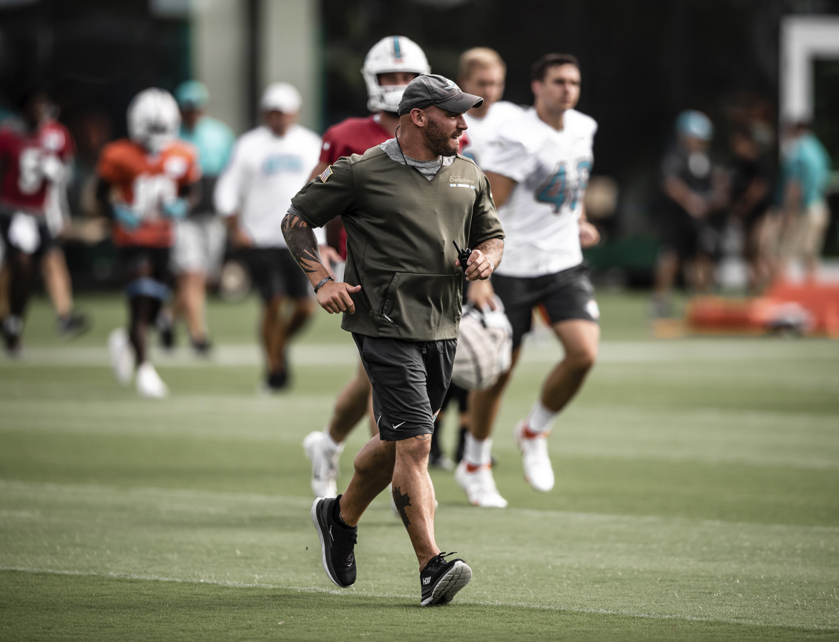Dolphins assistant strength and conditioning coach Adam Lachance runs on a practice field.
