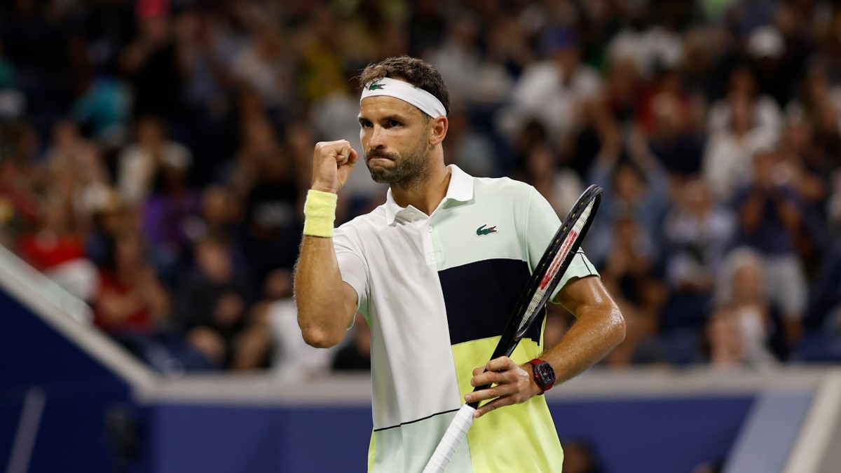 Grigor Dimitrov fist-pumps while holding a racket