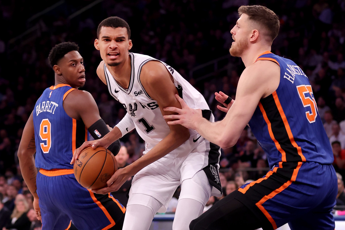 San Antonio Spurs center Victor Wembanyama (1) controls the ball against New York Knicks guard RJ Barrett (9) and New York Knicks center Isaiah Hartenstein (55) during the second quarter at Madison Square Garden.