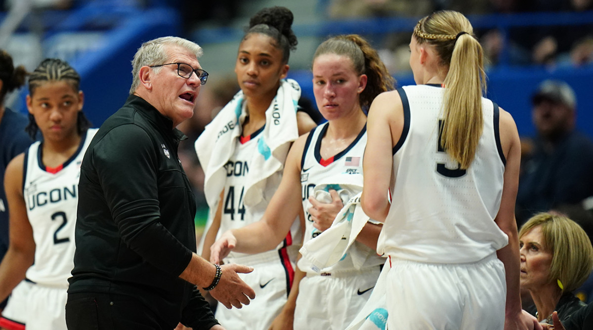 UConn coach Geno Auriemma talks with guard Paige Bueckers (5) as she comes off the court against Dayton.