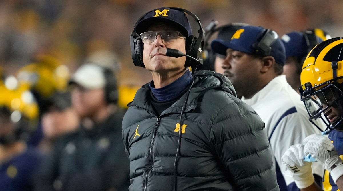 Michigan football coach Jim Harbaugh looks on from the sideline during a game.