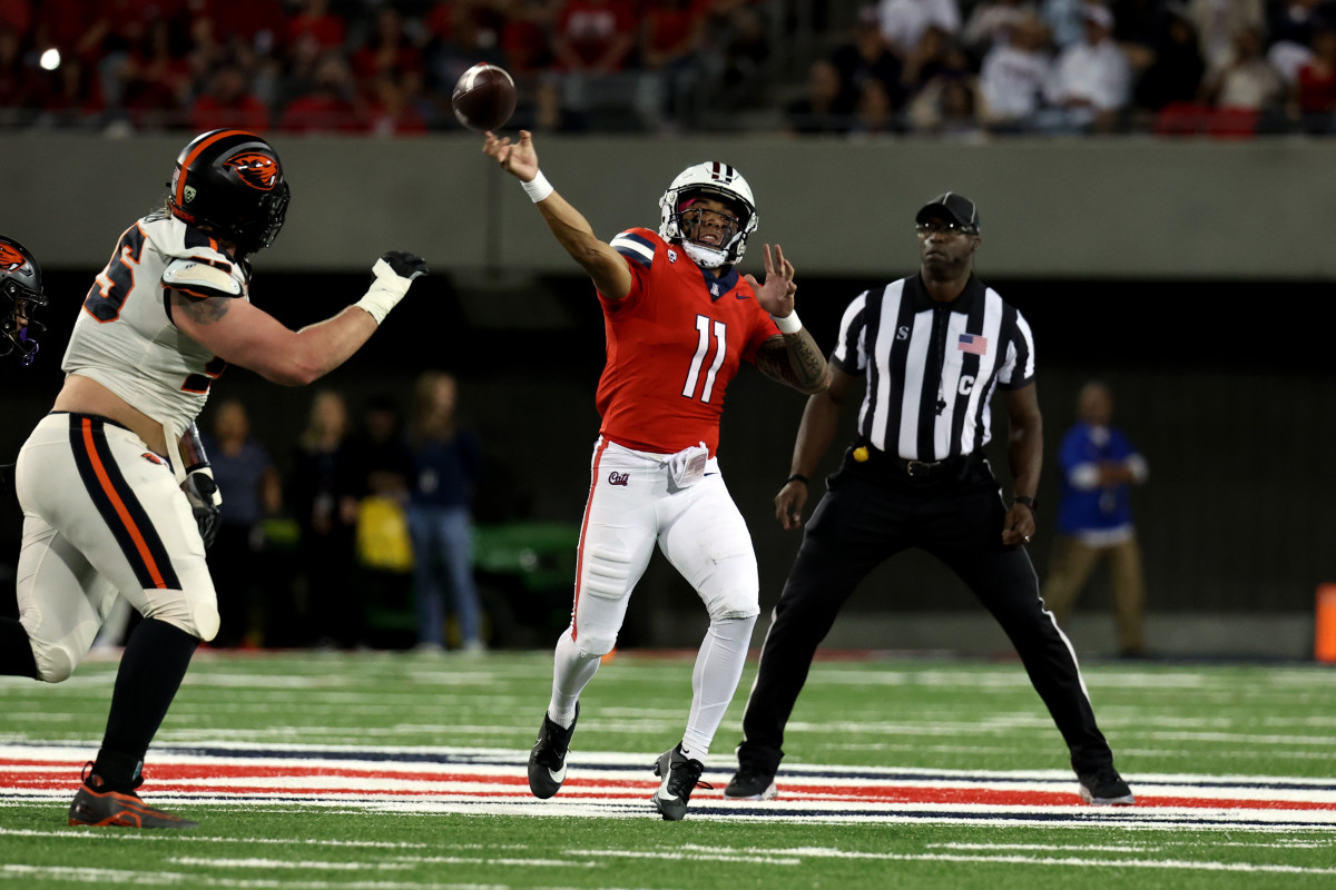 Oct 28, 2023; Tucson, Arizona, USA; Arizona Wildcats quarterback Noah Fifita #11 makes a pass down the field agaisnt Oregon State Beavers defensive lineman Joe Golden #95 during the first half at Arizona Stadium. Mandatory Credit: Zachary BonDurant-USA TODAY Sports