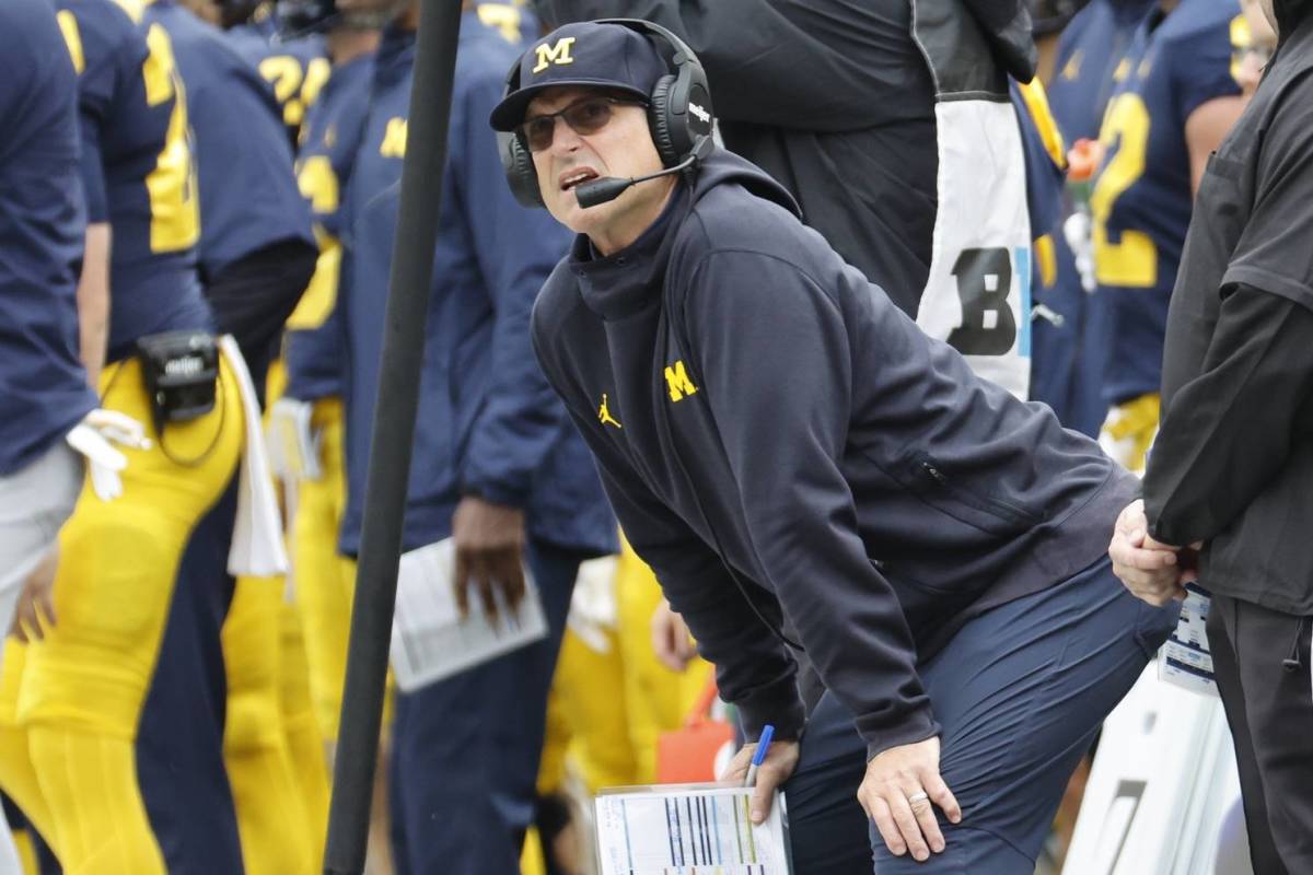 Michigan coach Jim Harbaugh looks on while coaching in a game.