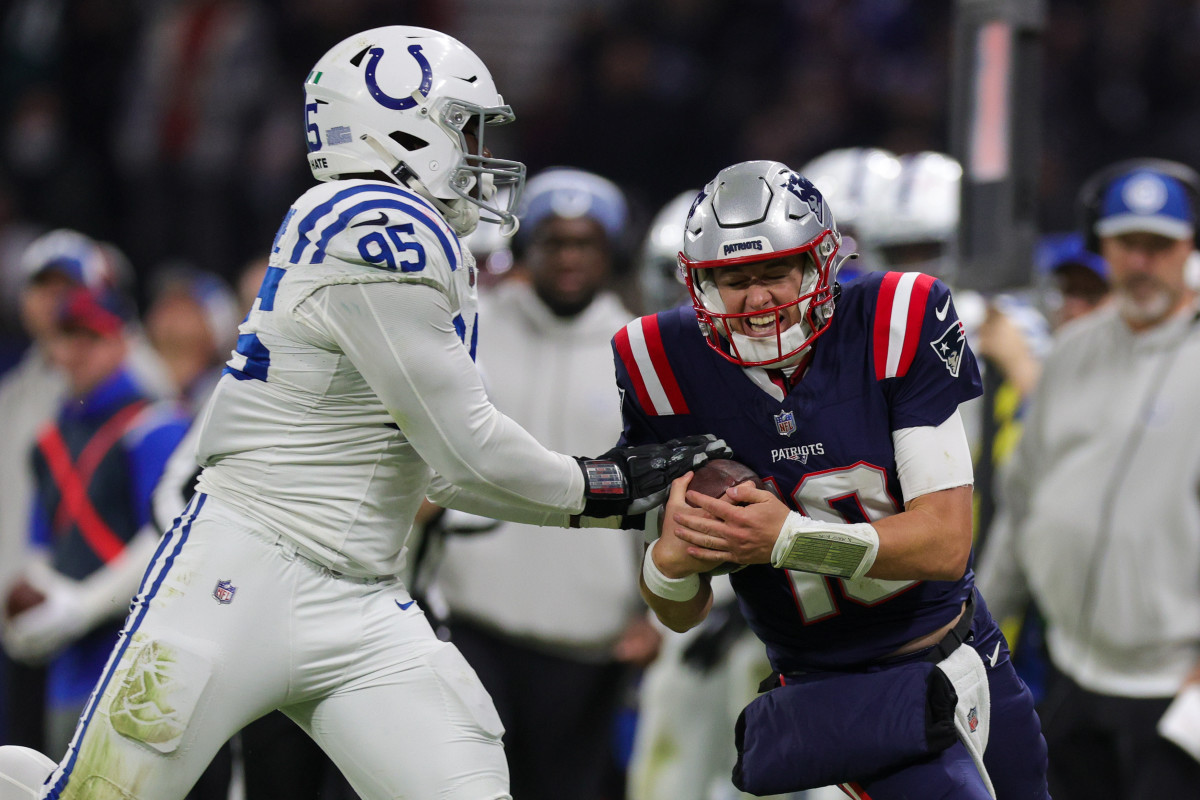 New England Patriots quarterback Mac Jones (10) is forced out of bounds by Indianapolis Colts defensive end Adetomiwa Adebawore (95) in the third quarter during an International Series game at Deutsche Bank Park.