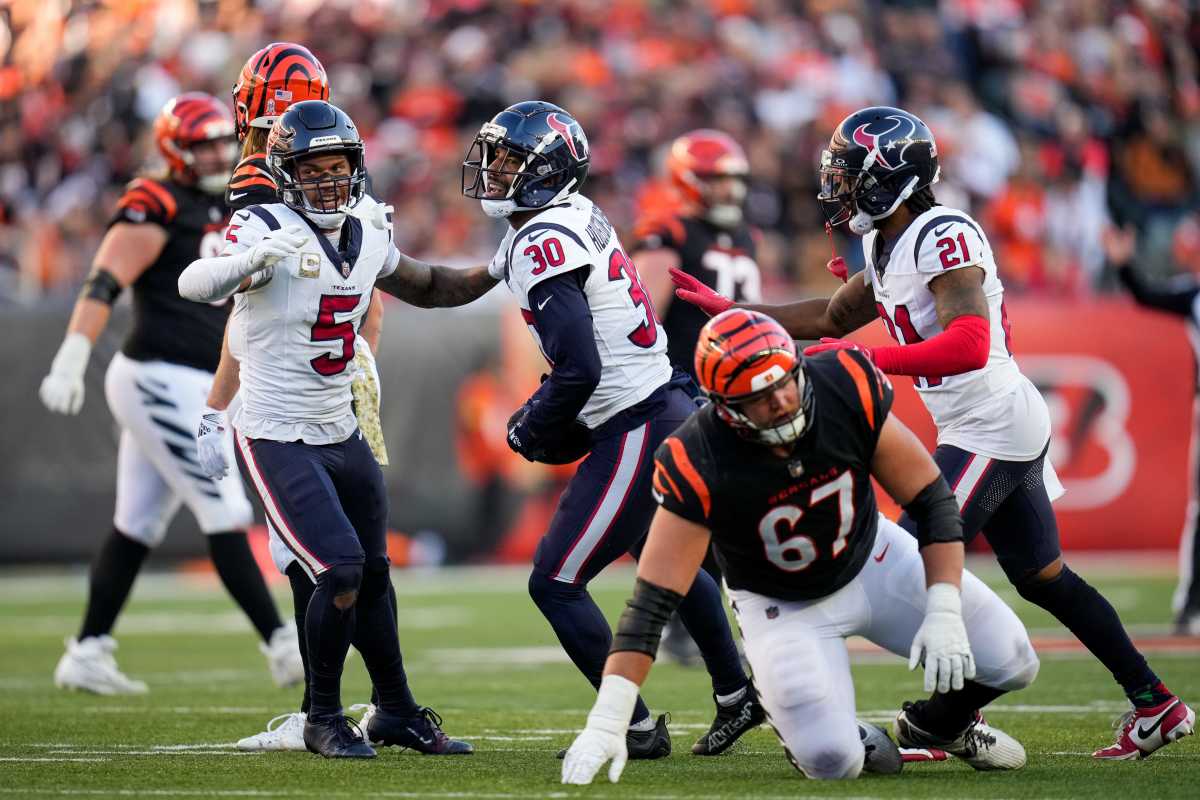DeAndre Houston-Carson holds the ball and is flanked by two teammates on his side after an interception