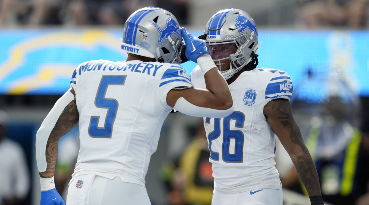 Lions running backs David Montgomery (left) and Jahmyr Gibbs celebrate by saluting each other after a touchdown.