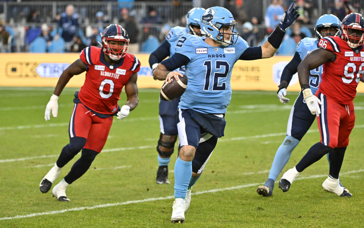 Nov 11, 2023; Toronto, Ontario, CAN; Toronto Argonauts quarterback Chad Kelly (12) scrambles out of the pocket as he is pursued by Montreal Alouettes defensive end Shawn Lemon (0) in the first half at BMO Field. Mandatory Credit: Dan Hamilton-USA TODAY Sports