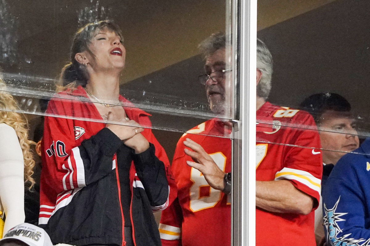 Recording artist Taylor Swift laughs while talking to Ed Kelce  during the second half of the game between the Kansas City Chiefs and Denver Broncos at GEHA Field at Arrowhead Stadium.