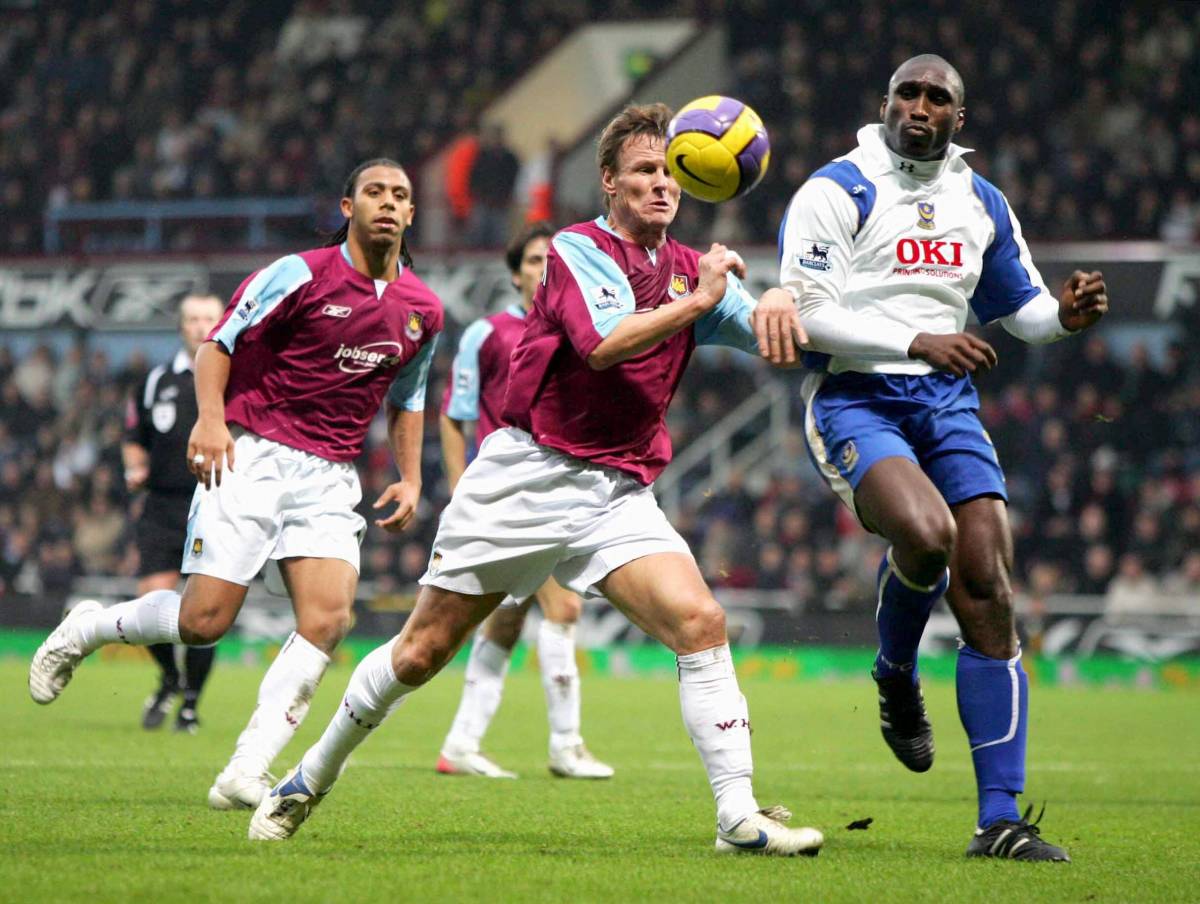 West Ham striker Teddy Sheringham pictured (center) battling for the ball with Portsmouth defender Sol Campbell (right) during a Premier League game in December 2006