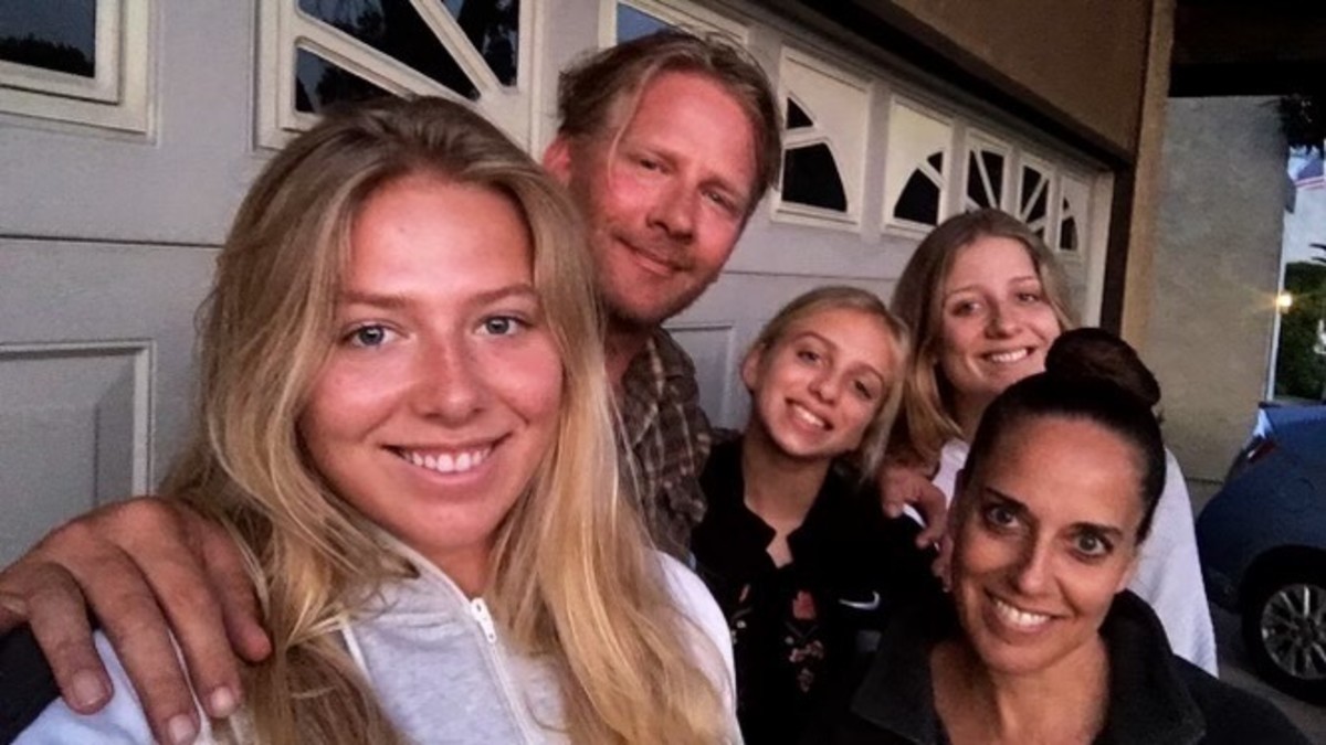 Katie takes a selfie with her parents and two sisters in front of their house’s garage.