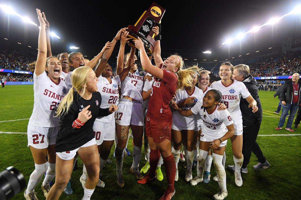 The Stanford players celebrate their national championship by huddling together and hoisting the trophy.