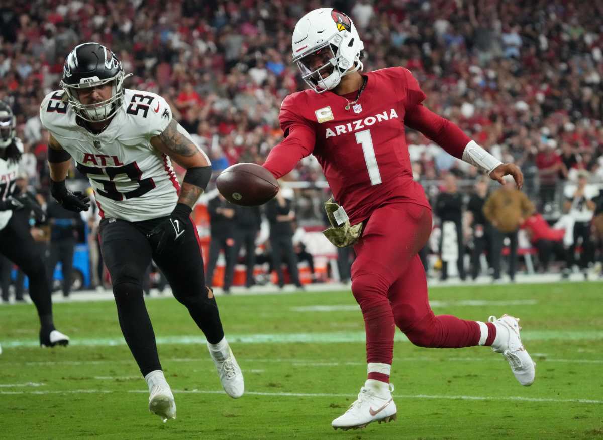 Kyler Murray runs with the ball in one extended arm reaching forward