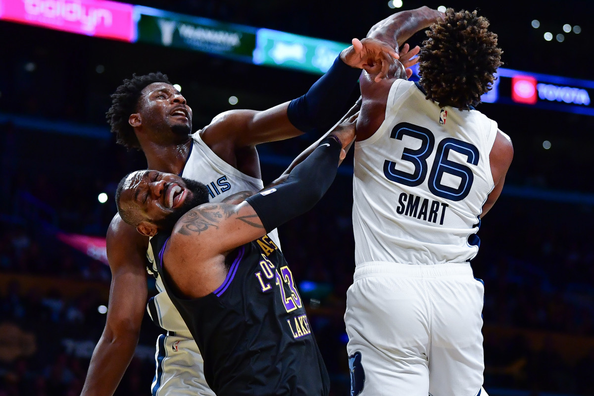 Los Angeles Lakers forward LeBron James scores a basket between Memphis Grizzlies guard Marcus Smart and forward Jaren Jackson Jr. during the first half at Crypto.com Arena.