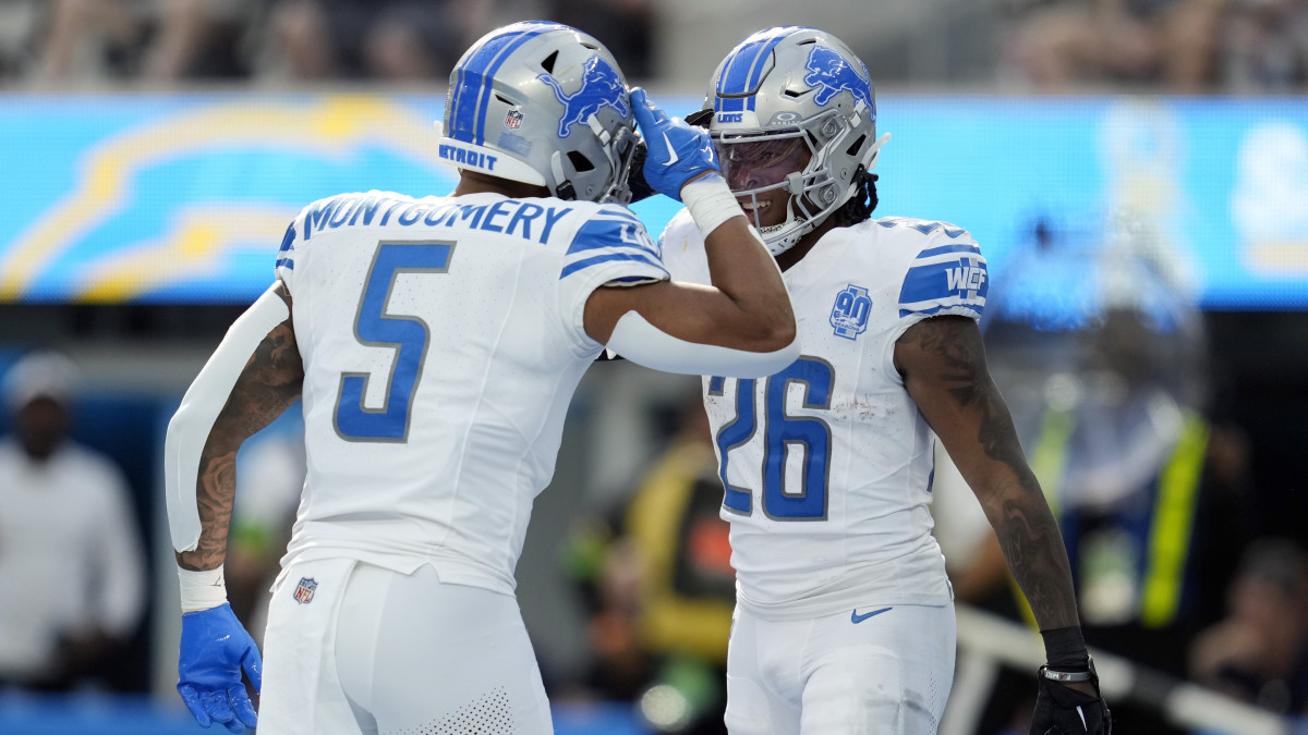David Montgomery and Jahmyr Gibbs celebrate on the field