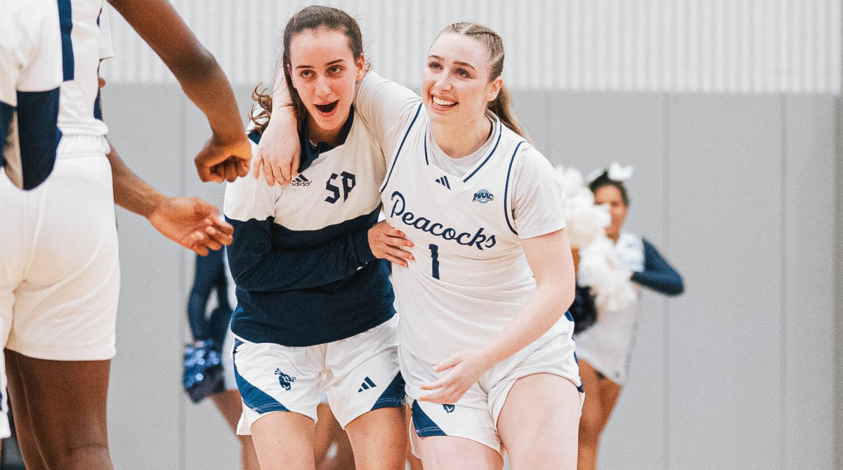 Rachel Kuhl and Lara Aguzzi celebrate Saint Peter’s women’s basketballs first win in more than 600 days.