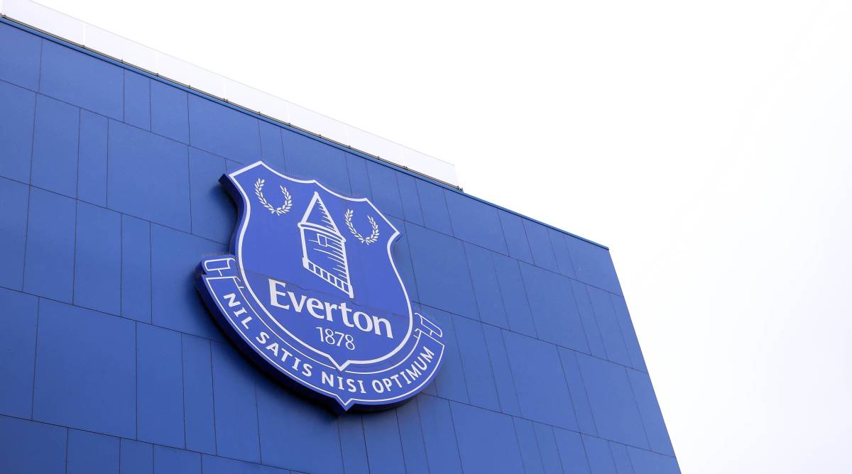 A blue Everton crest on the front of a building.