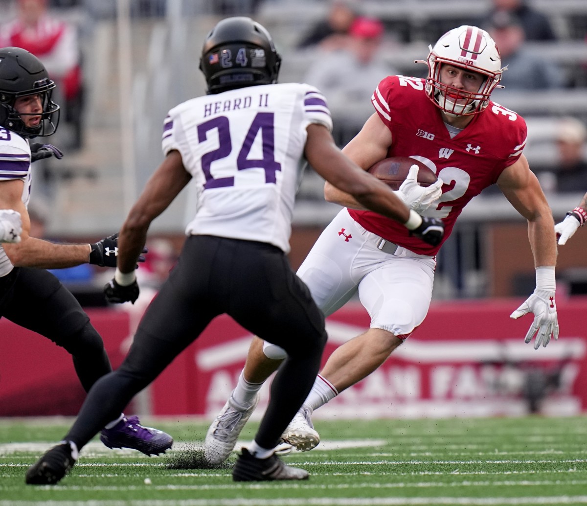 Nov 11, 2023; Madison, Wisconsin, USA; Wisconsin quarterback Tanner Mordecai (8) runs for a first down against the Northwestern Wildcats during the third quarter at Camp Randall Stadium. Mandatory Credit: Mark Hoffman-USA TODAY Sports