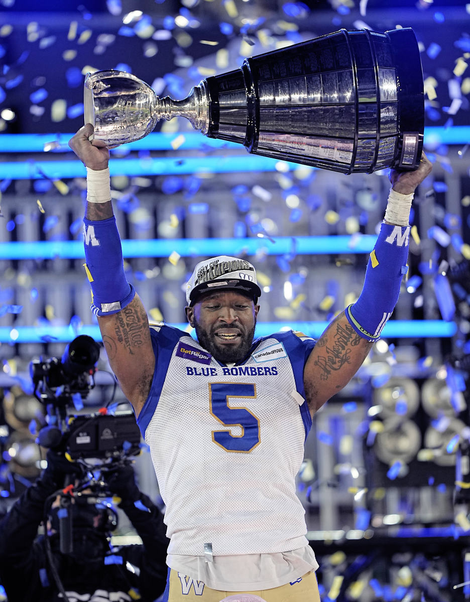 Dec 12, 2021; Hamilton, Ontario, CAN; Winnipeg Blue Bombers defensive lineman Willie Jefferson (5) hoists the Grey Cup after defeating the Hamilton Tiger-Cats during the 108th Grey Cup football game at Tim Hortons Field. Mandatory Credit: John E. Sokolowski-USA TODAY Sports