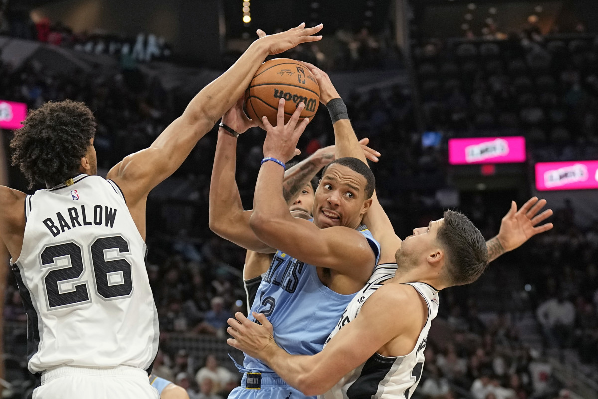 Memphis Grizzlies guard Desmond Bane (22) looks to pass the ball while defended by San Antonio Spurs forwards Dom Barlow (26) and Doug McDermott (17) during the second half at Frost Bank Center.
