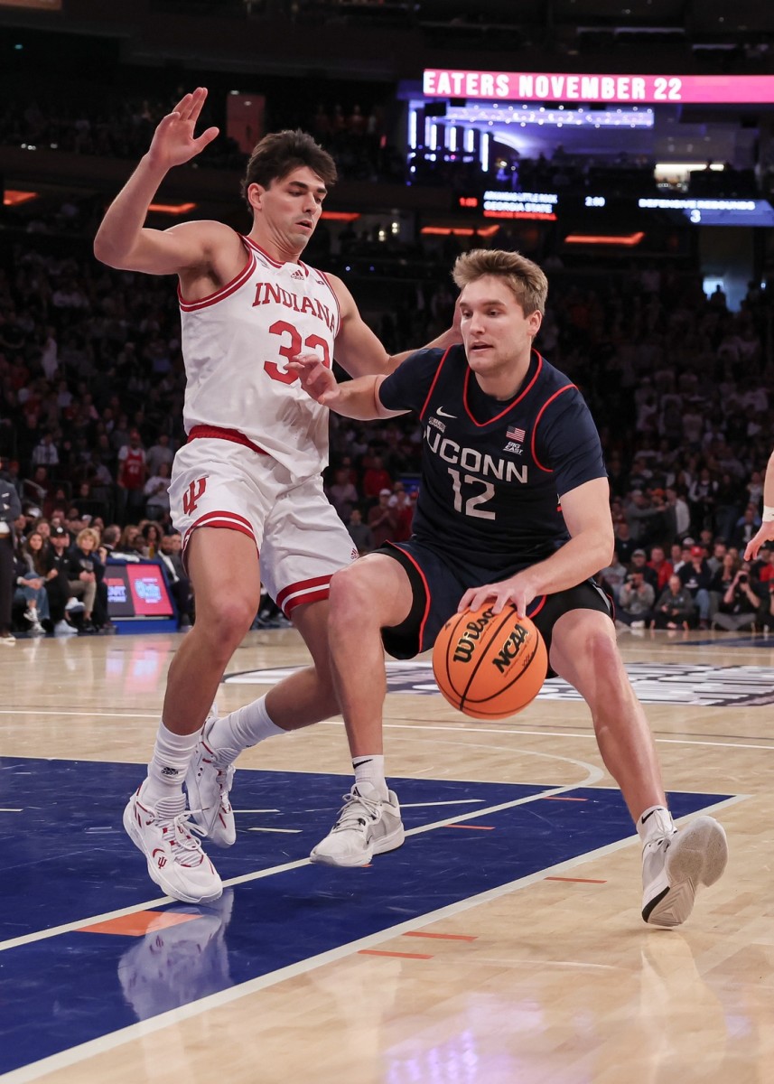 Connecticut Huskies guard Cam Spencer (12) dribbles against Indiana Hoosiers guard Trey Galloway (32) during the first half at Madison Square Garden. 
