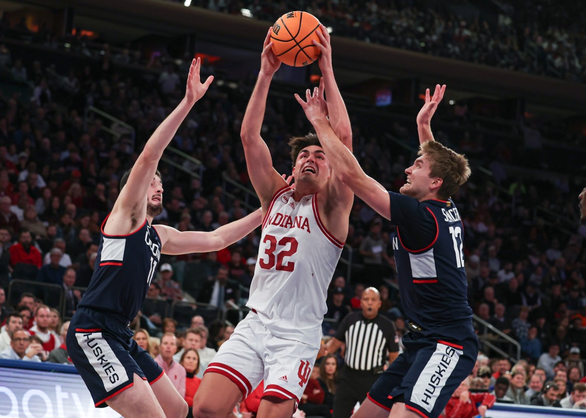 Indiana Hoosiers guard Trey Galloway (32) drives to the basket as Connecticut Huskies guard Cam Spencer (12) and forward Alex Karaban (11) defend during the second half at Madison Square Garden. 