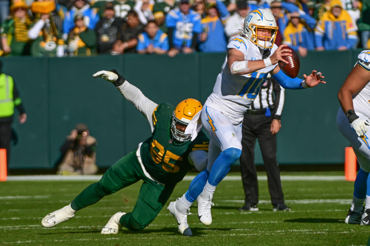 Los Angeles Chargers quarterback Justin Herbert scrambles past Green Bay Packers defensive tackle Devonte Wyatt in the second quarter at Lambeau Field.