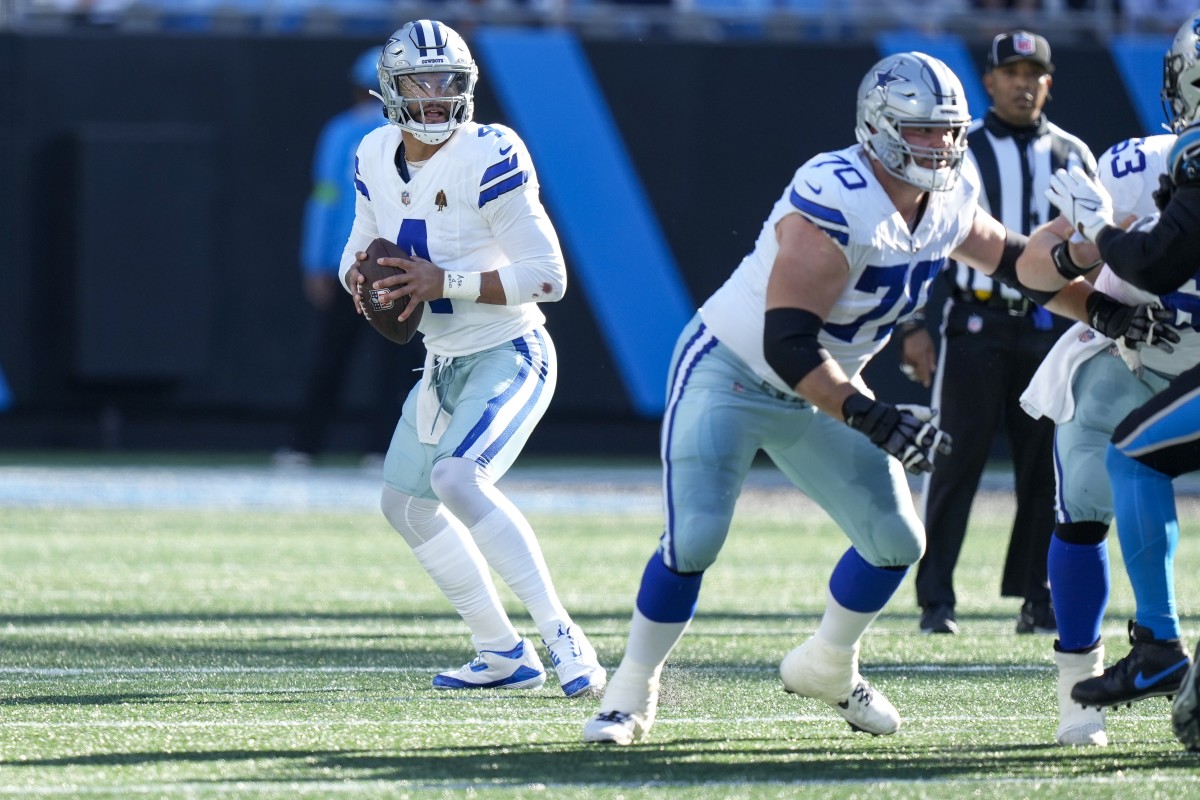 Dak Prescott steps back holding the ball, scanning the field