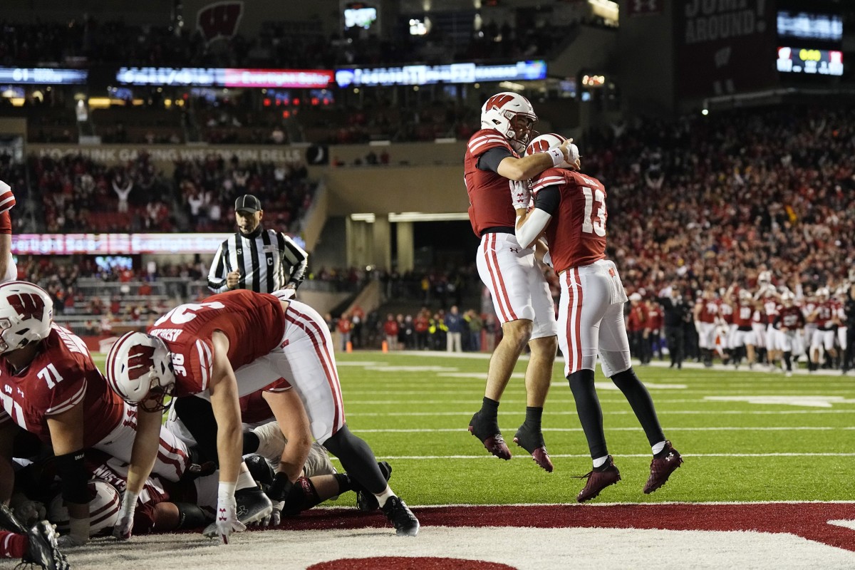 Nov 18, 2023; Madison, Wisconsin, USA; Wisconsin Badgers quarterback Tanner Mordecai (8) celebrates with wide receiver Chimere Dike (13) after scoring a touchdown during overtime against the Nebraska Cornhuskers at Camp Randall Stadium. Mandatory Credit: Jeff Hanisch-USA TODAY Sports