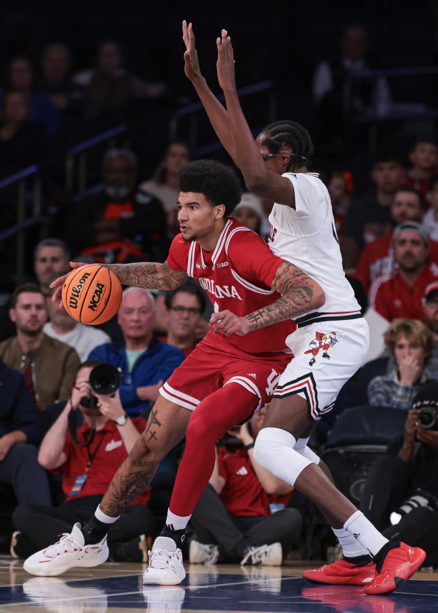 Indiana Hoosiers forward Anthony Walker (4) dribbles against Louisville Cardinals center Dennis Evans (11) during the first half at Madison Square Garden. 