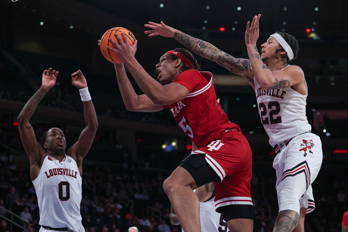 Indiana Hoosiers forward Malik Reneau (5) drives to the basket as Louisville Cardinals guard Tre White (22) and guard Mike James (0) defend during the second half at Madison Square Garden. 