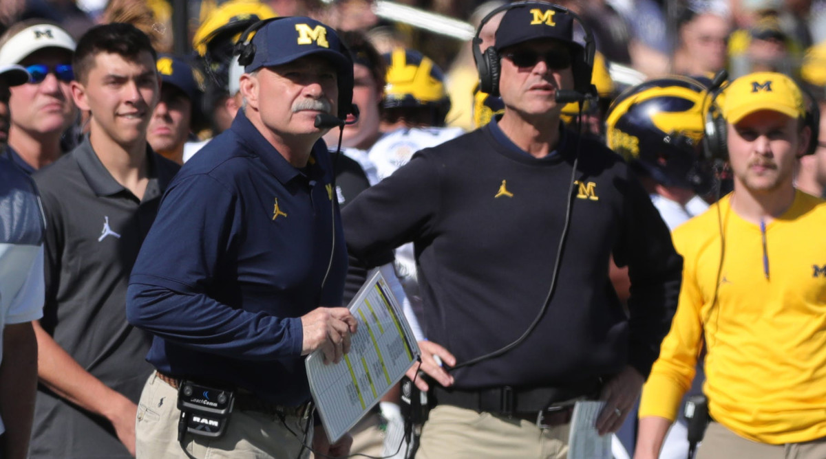 Michigan defensive coordinator Don Brown and coach Jim Harbaugh watch a play from the sidelines of the 2020 Citrus Bowl.