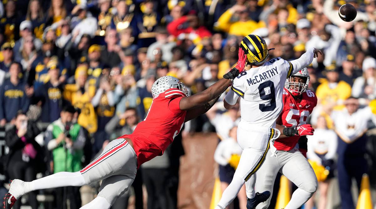 Michigan’s J.J. McCarthy throws a pass to avoid a sack vs. Ohio State.