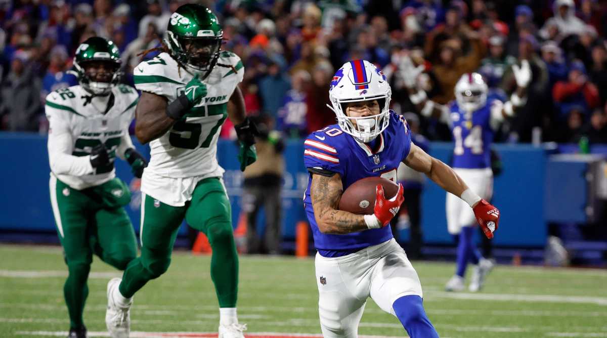 Bills wide receiver Khalil Shakir, right center, races for a touchdown against a trailing Jets defense while a teammate raises his arms in triumph in the bavckground