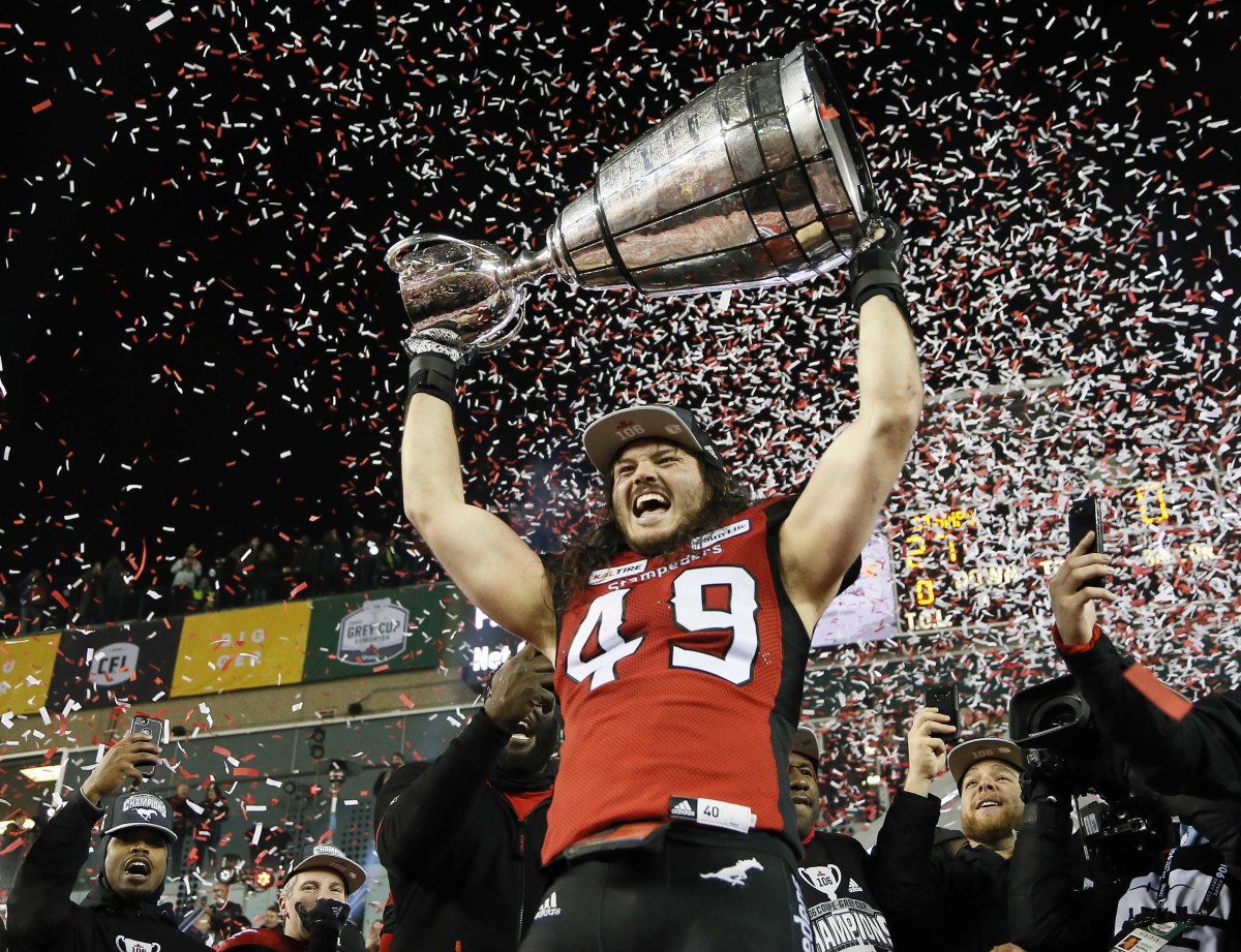 Nov 25, 2018; Edmonton, Alberta, CAN; Calgary Stampeders linebacker Alex Singleton (49) hoists the Grey Cup after defeating Ottawa during the 106th Grey Cup game at The Brick Field at Commonwealth Stadium. Mandatory Credit: John E. Sokolowski-USA TODAY Sports