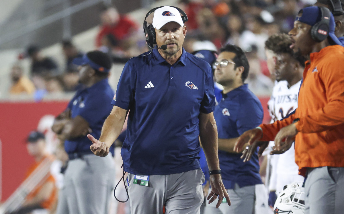 Jeff Traylor walks along the sideline gesturing with his right hand