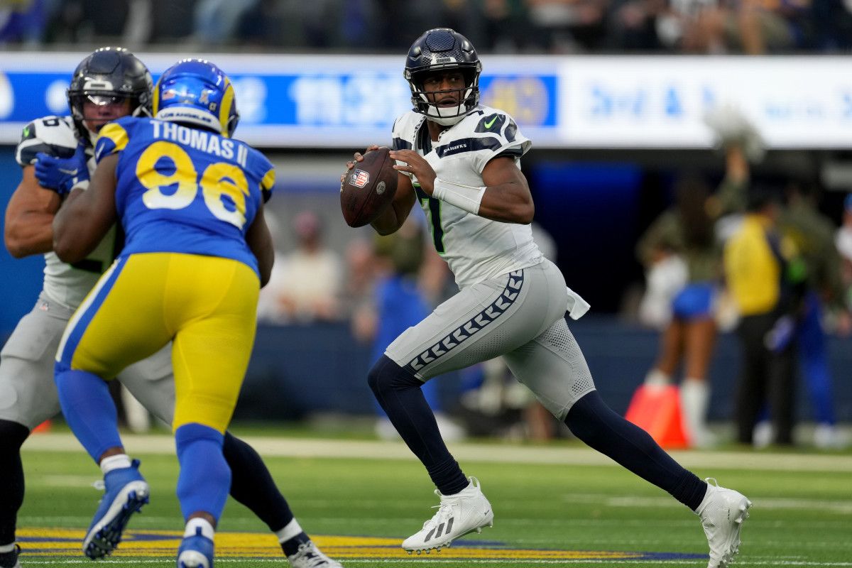 Geno Smith runs with the ball getting ready to throw