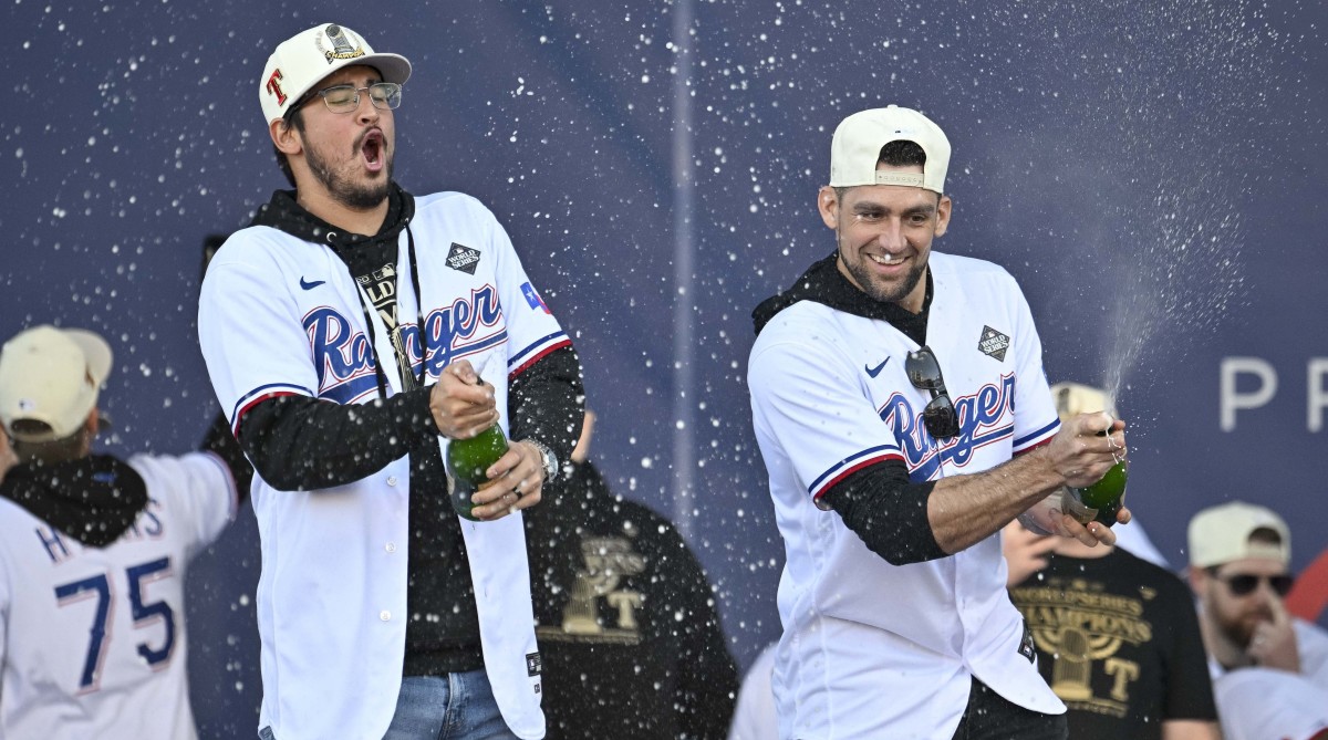Rangers pitcher Dane Dunning, left and pitcher Nathan Eovaldi spray the crowd with champagne during the 2023 World Series champion celebration