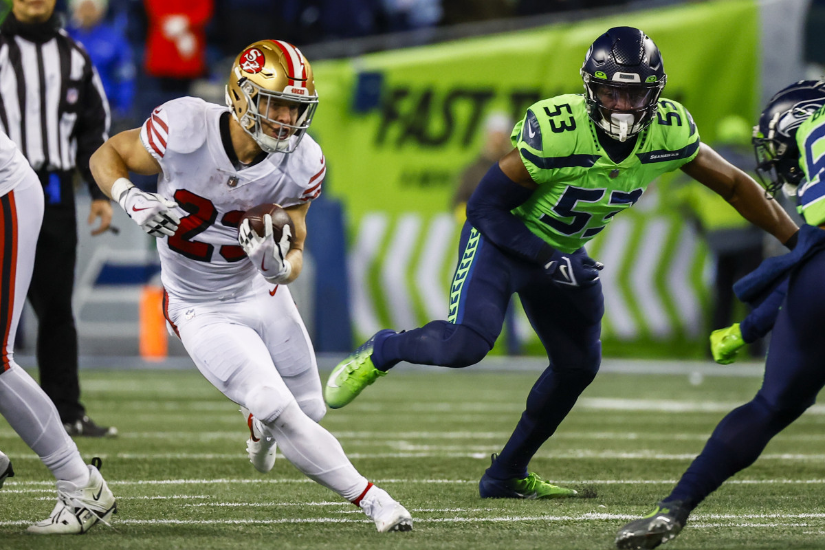 San Francisco 49ers running back Christian McCaffrey (23) rushes against the Seattle Seahawks during the second quarter at Lumen Field. Seattle Seahawks linebacker Boye Mafe (53) follows the play at right.